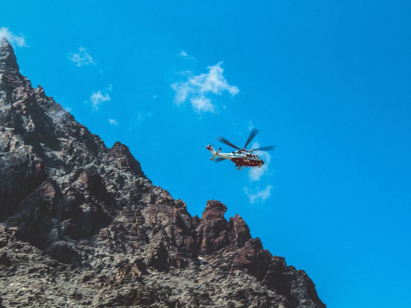 You should prepare for your Slieve Donard hike to avoid accidents. This image shows a mountain rescue helicopter against a blue sky.