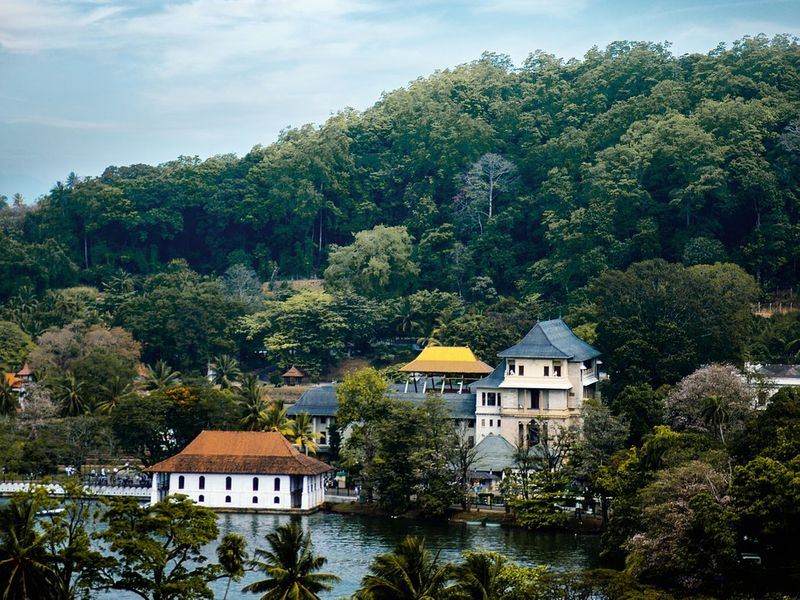 Kandy is one of the best of Sri Lanka's historical places. This image shows a series of waterfront buildings framed by greenery.