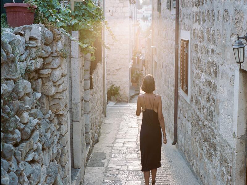 lady walking down a street in Croatia.