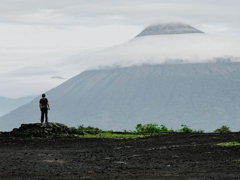 A tourist stood by a volcano.